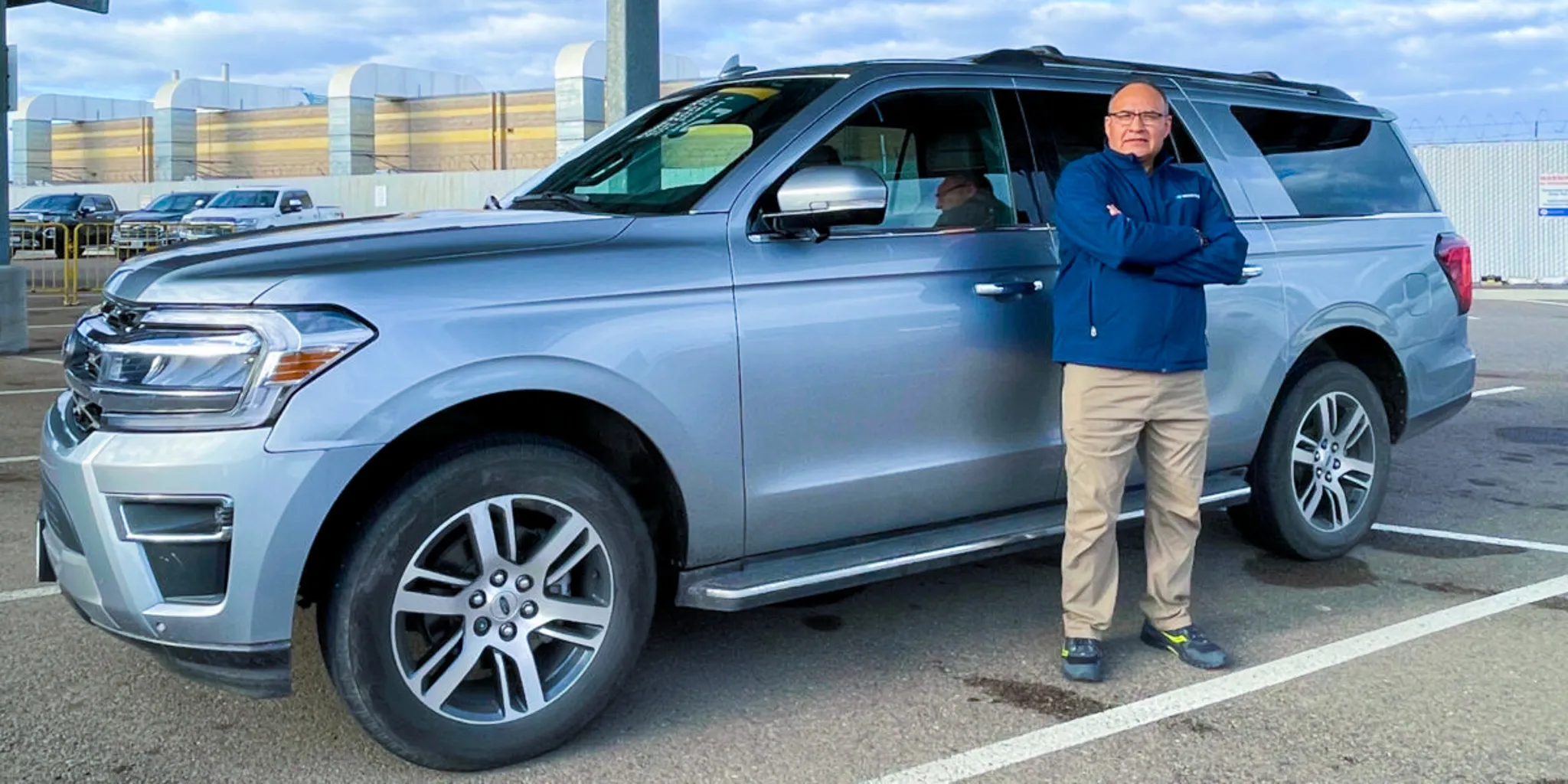 Clinic transport vehicle with a staff member standing beside it in a parking lot